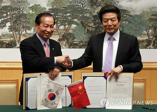 韩国广播通信委员会委员长李敬（左）在17日在北京会见中国国家新闻出版广电总局局长蔡赴朝李敬，并签订《韩中有关广播和电视领域合作谅解备忘录》。（韩联社）