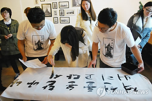 31日，参加活动的人员在条幅上书写李舜臣的《乱中日记》（韩联社）