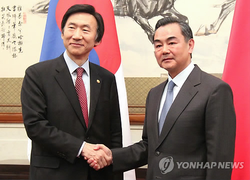 资料图片：韩国外交部长官尹炳世（左）和中国外交部长王毅（韩联社）